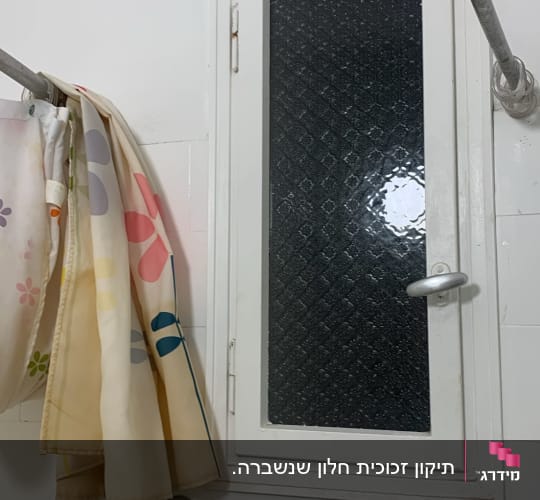 חלון זכוכית עם וילון צבעוני בחדר אמבטיה